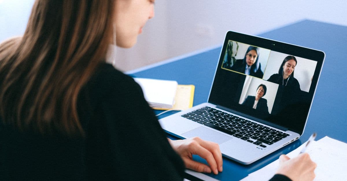 Professional practicing interview responses with an AI assistant on laptop